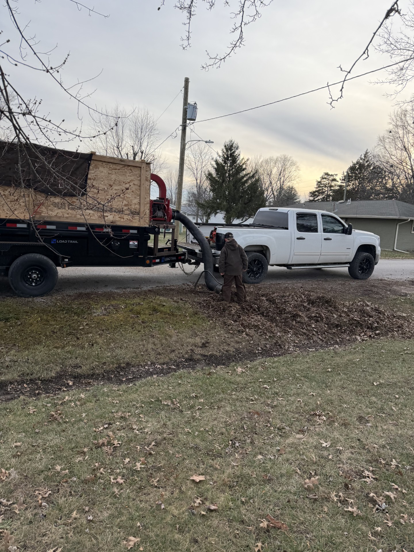 Truck and trailer with leaf vacuum collecting fall leaves